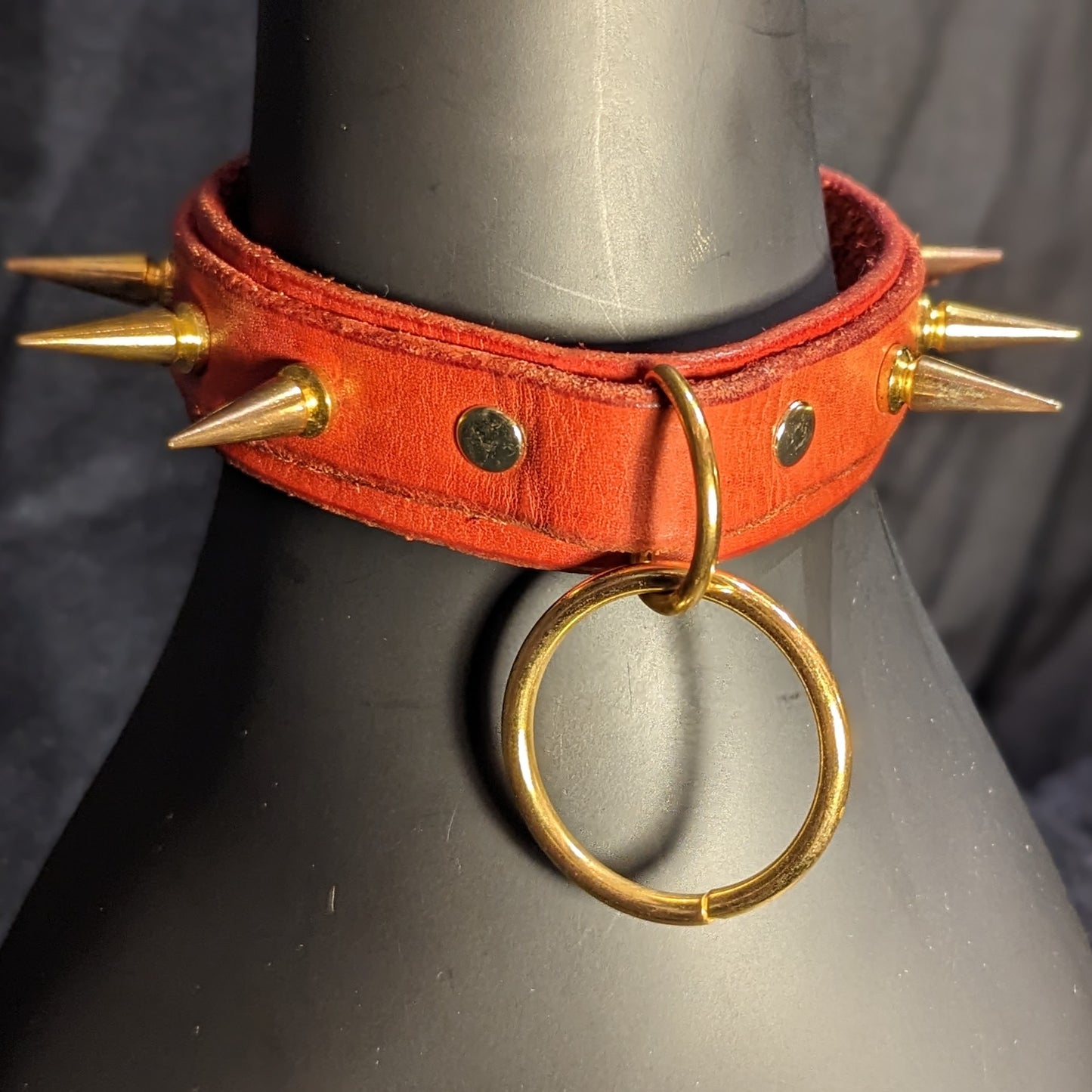 Red spiked collar by Smell My Leather. This collar has two layers of leather with 1" spikes and gold color hardware