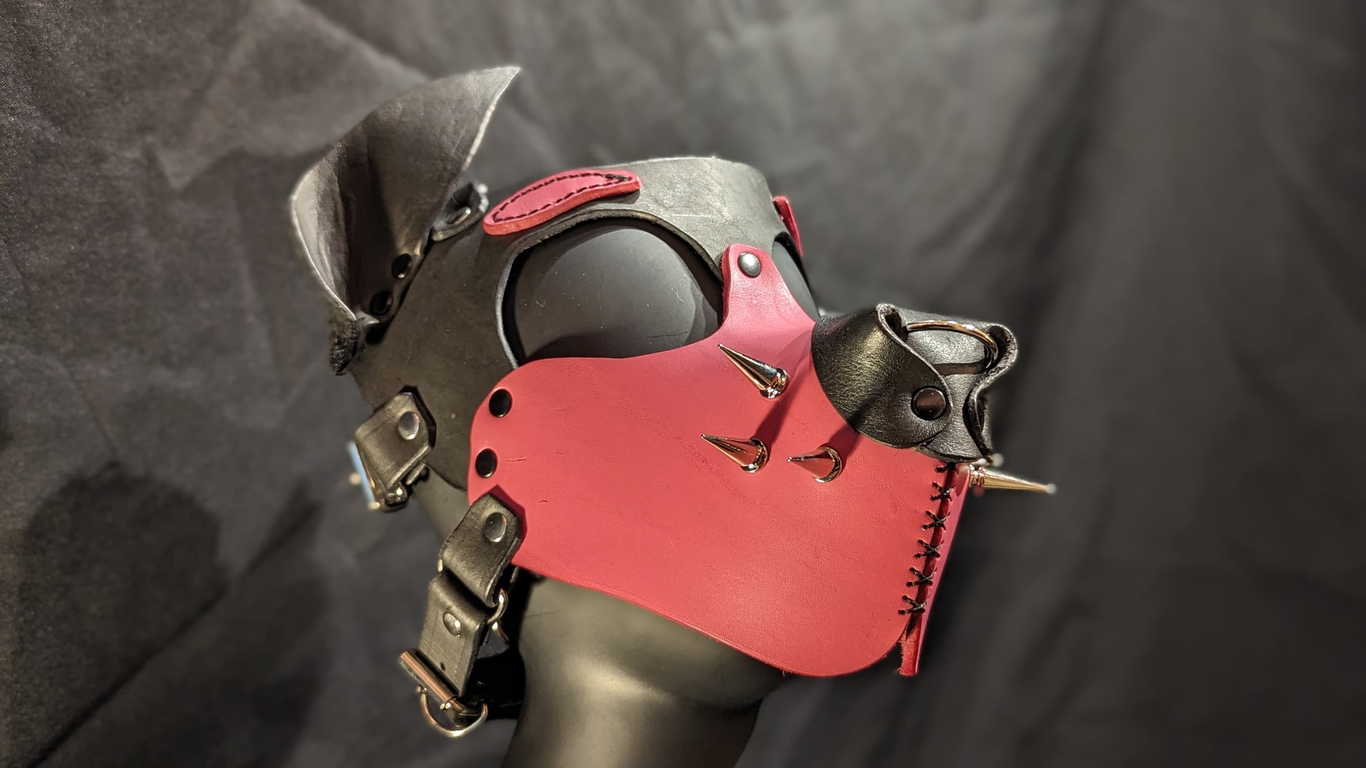 Handmade puphood with a black base color and bright bubblegum pink muzzle and eyebrow and 1 inch silver treecone spike whiskers.. You can see the right side of the hood in this image.